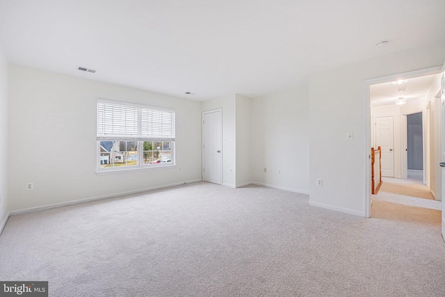 empty room with light carpet, baseboards, and visible vents