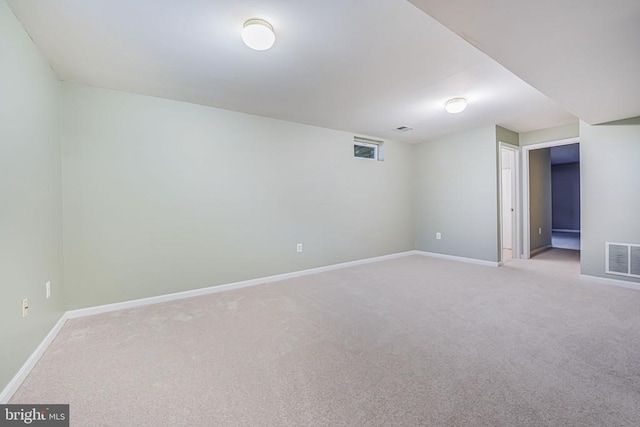 carpeted empty room featuring visible vents and baseboards