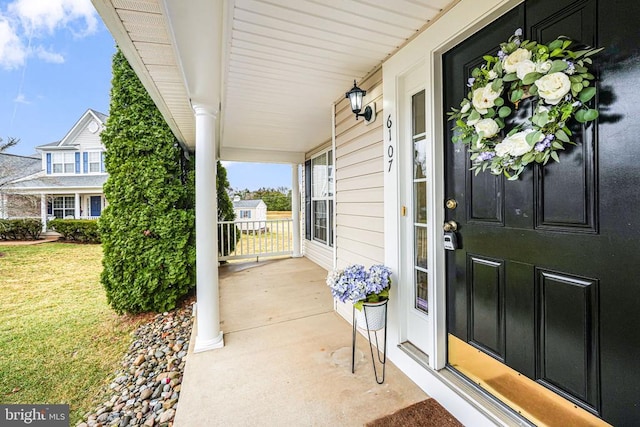 property entrance with a porch and a lawn