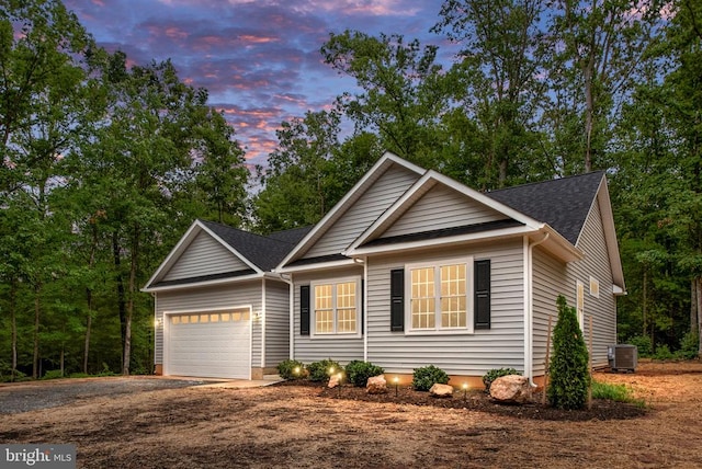 view of front of house with a garage and central air condition unit