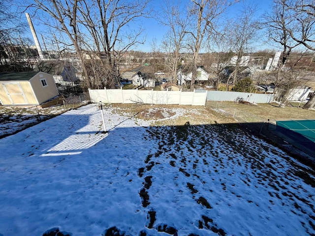 snowy yard with a storage shed