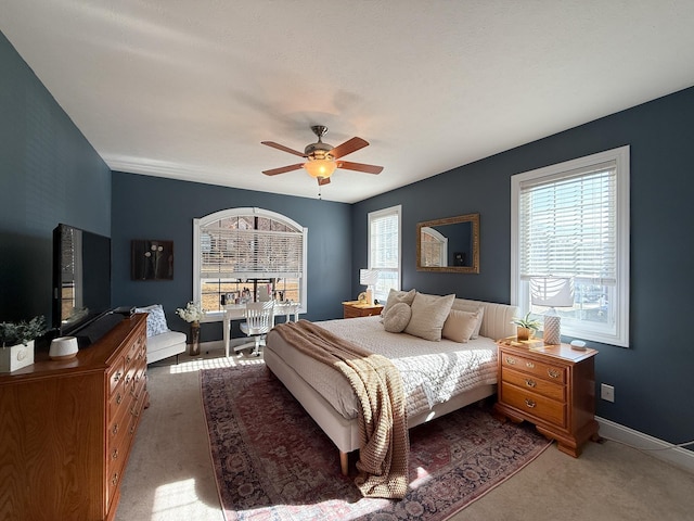 carpeted bedroom with baseboards and a ceiling fan