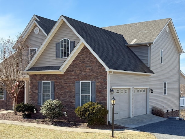 traditional-style home with driveway, an attached garage, and roof with shingles