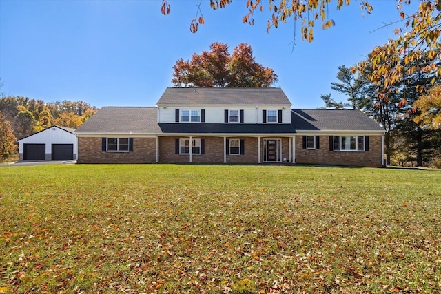 view of front facade featuring a garage, an outbuilding, and a front yard