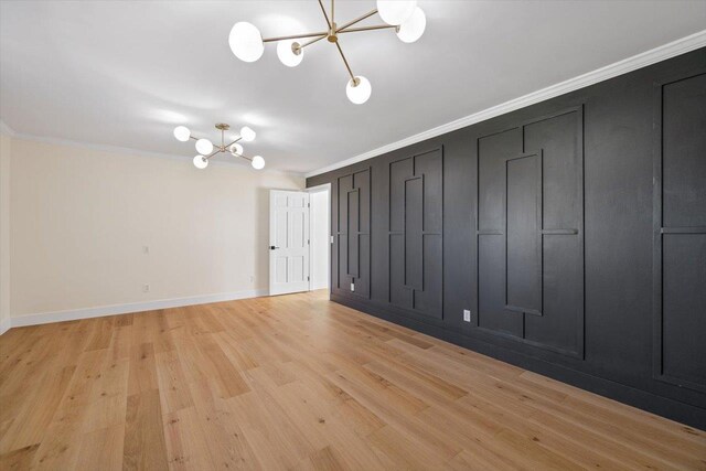 unfurnished room featuring a chandelier, baseboards, crown molding, and light wood finished floors