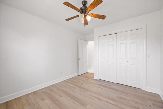 unfurnished bedroom featuring light wood-type flooring, a closet, ceiling fan, and baseboards