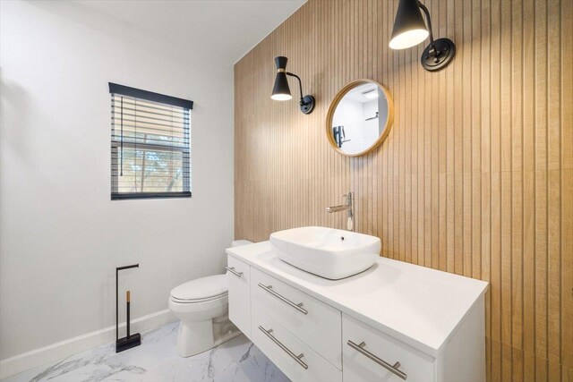 bathroom featuring marble finish floor, baseboards, vanity, and toilet