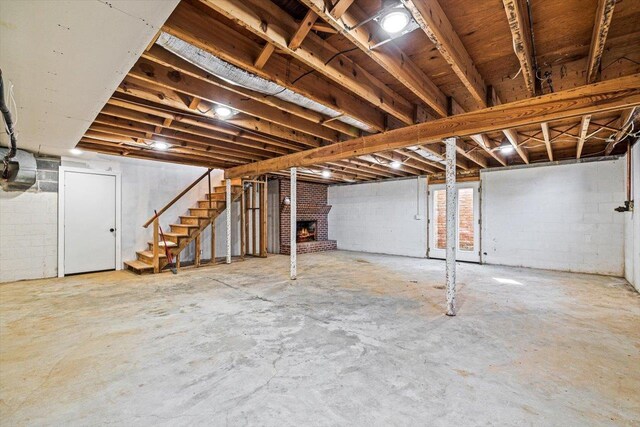 below grade area with a brick fireplace and stairway