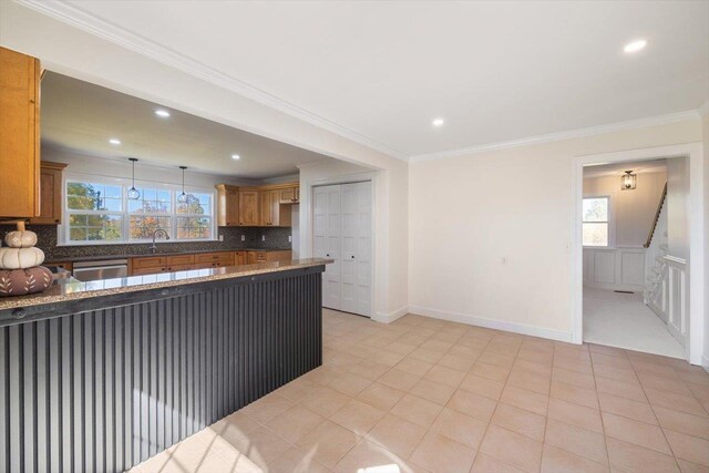 kitchen featuring ornamental molding, decorative light fixtures, a sink, and decorative backsplash