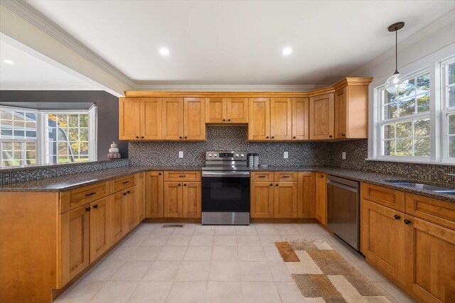 kitchen with hanging light fixtures, brown cabinets, stainless steel appliances, and decorative backsplash