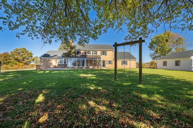 rear view of property with a sunroom and a lawn