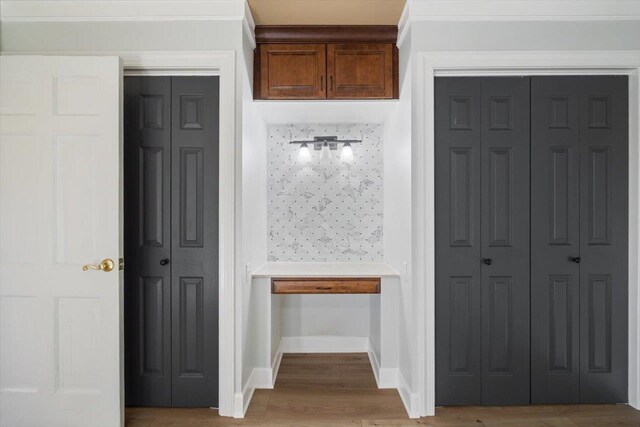 interior space with light wood finished floors, baseboards, brown cabinets, and light countertops