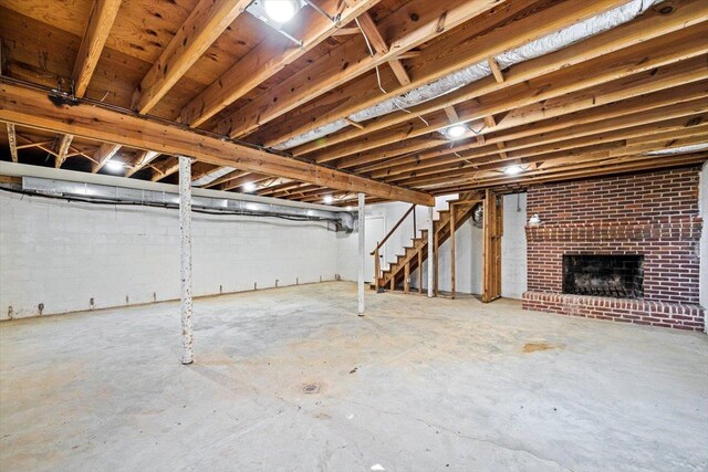 unfinished below grade area featuring stairway and a brick fireplace