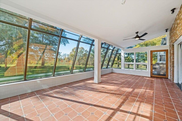 unfurnished sunroom featuring a water view, vaulted ceiling, and ceiling fan