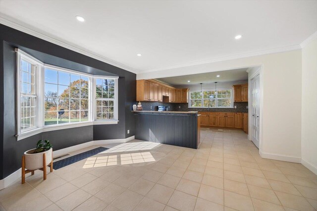 kitchen with ornamental molding, dark countertops, backsplash, and brown cabinets