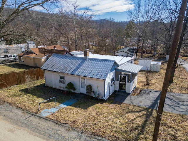 view of front of property featuring metal roof and fence