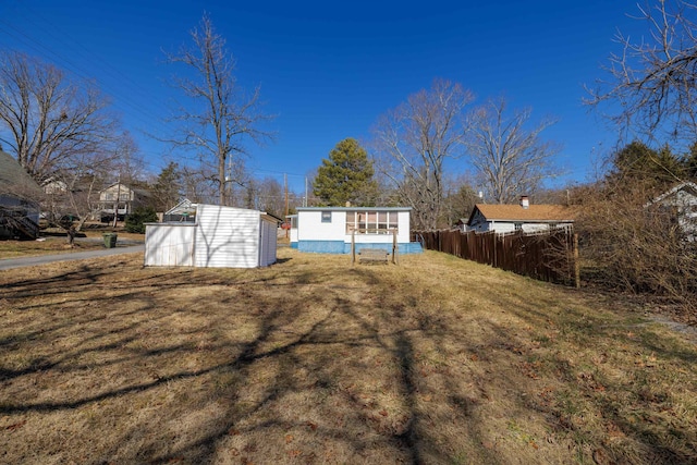 exterior space with a storage shed, a yard, an outdoor structure, and fence