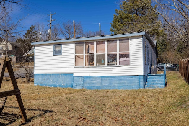 view of side of home with a yard and fence