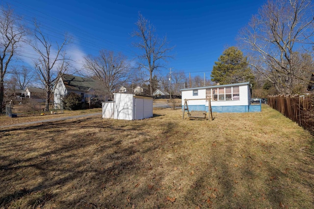 view of yard featuring an outbuilding, fence, and a storage unit