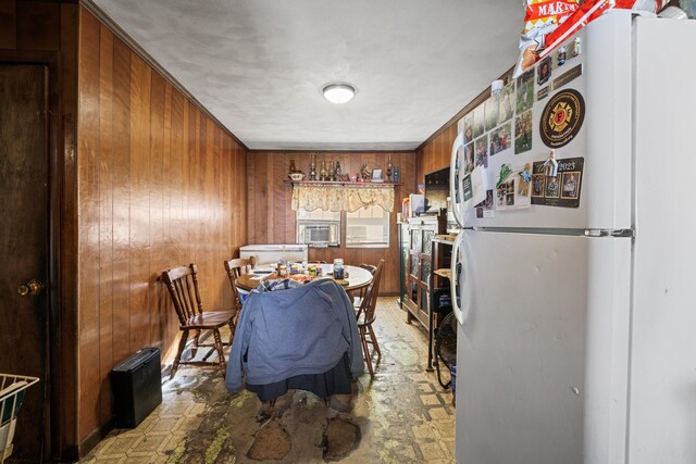 dining room with cooling unit and wood walls