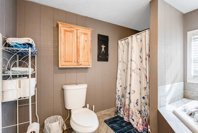 bathroom featuring toilet, shower with separate bathtub, and a textured ceiling