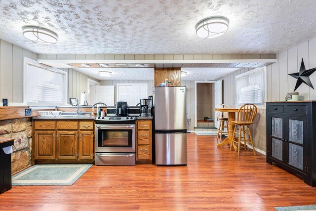 kitchen featuring stainless steel appliances, hardwood / wood-style flooring, and a textured ceiling