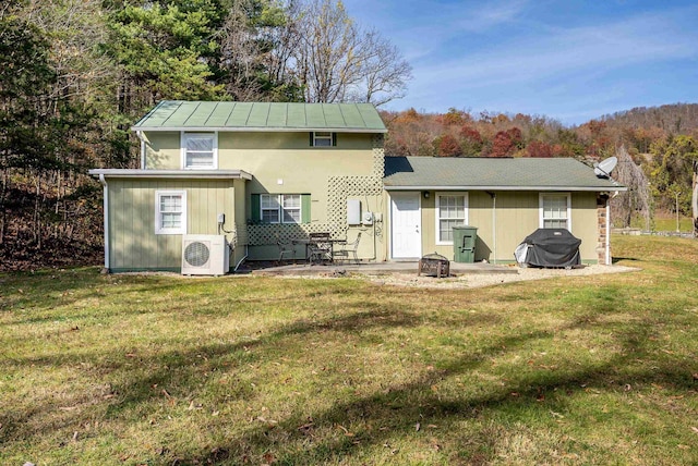 rear view of property featuring a patio area, ac unit, and a lawn