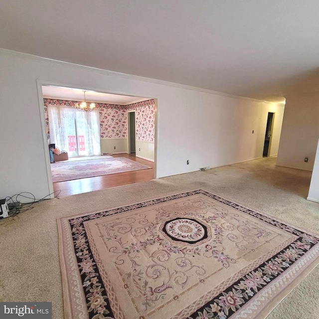 empty room with crown molding, carpet floors, and a chandelier