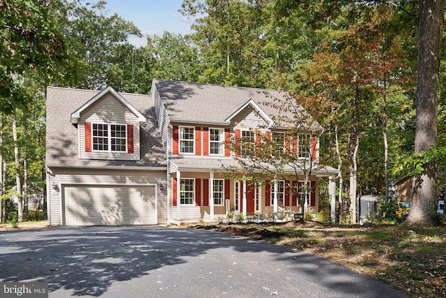 colonial home with a garage and a porch