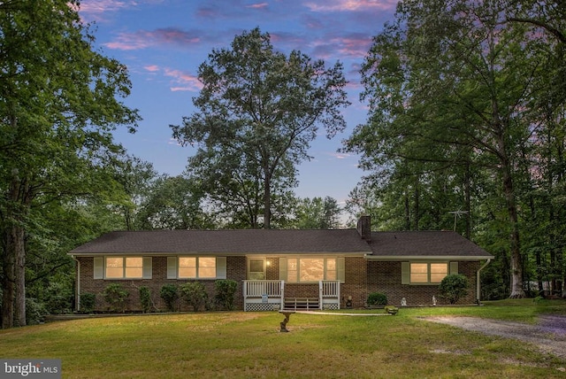 ranch-style house featuring a porch and a lawn