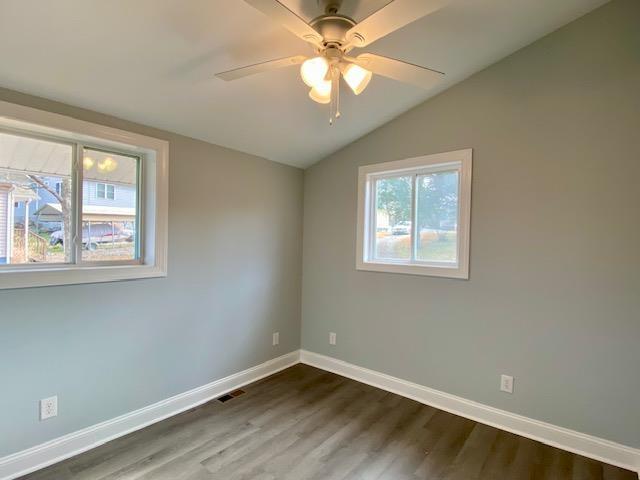 spare room with lofted ceiling, dark hardwood / wood-style floors, and ceiling fan