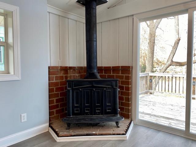 details featuring a wood stove and wood-type flooring