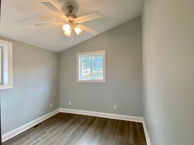 unfurnished room with ceiling fan, vaulted ceiling, and wood-type flooring