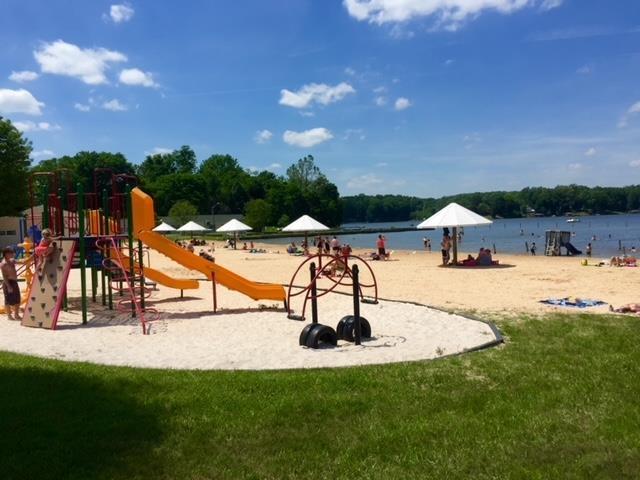 view of jungle gym with a lawn and a water view