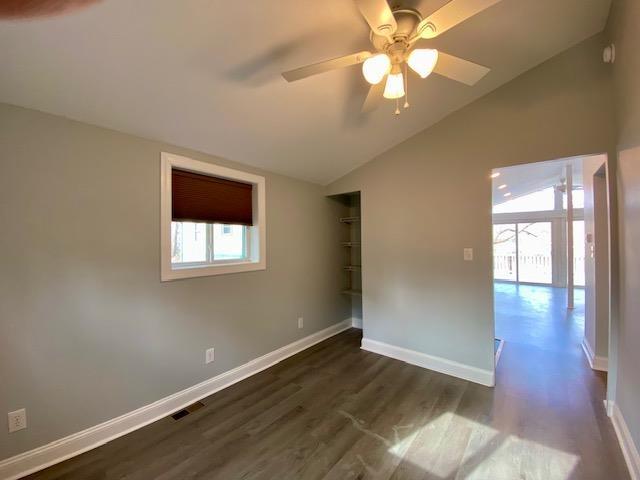 unfurnished room with dark hardwood / wood-style flooring, ceiling fan, and lofted ceiling