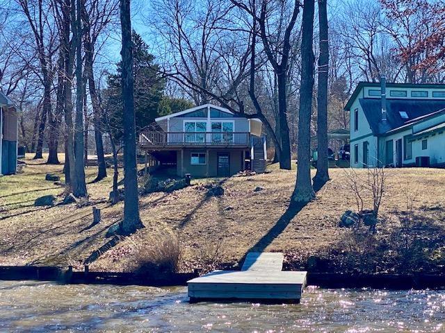 rear view of property with a wooden deck, a yard, and central AC