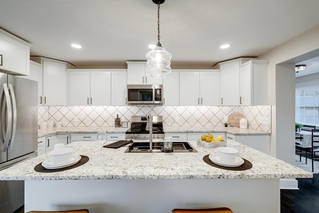 kitchen with pendant lighting, white cabinetry, a breakfast bar area, and stainless steel appliances