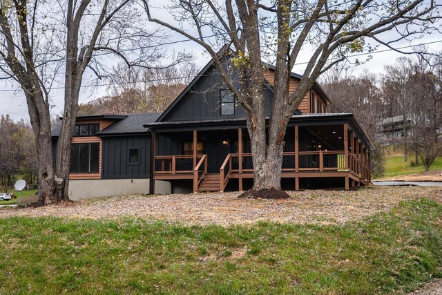 back of house featuring a sunroom and a lawn