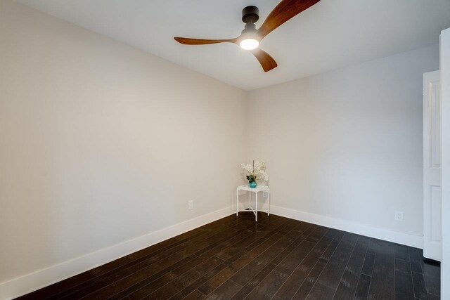 empty room with dark wood-type flooring and ceiling fan