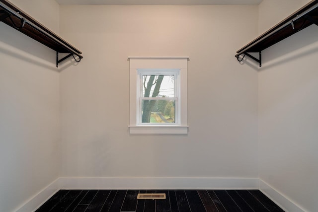 walk in closet with wood-type flooring