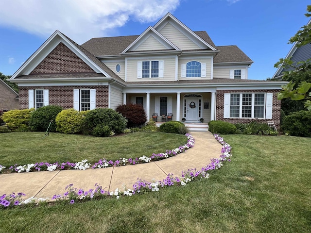 view of front of home with a porch and a front yard