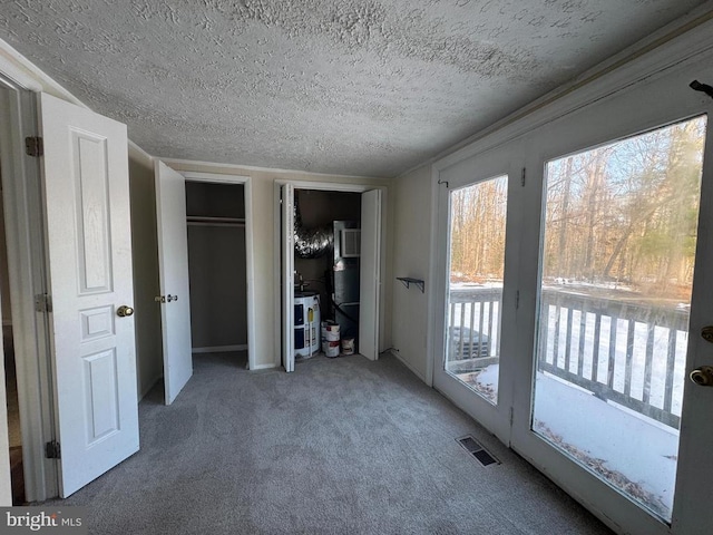 unfurnished bedroom featuring access to exterior, carpet floors, multiple closets, and a textured ceiling