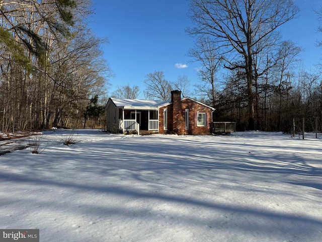 view of snowy exterior featuring covered porch