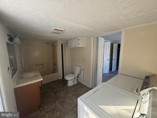 full bathroom featuring shower / bathing tub combination, vanity, toilet, washing machine and dryer, and a textured ceiling