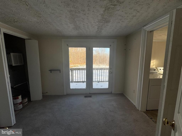 empty room featuring carpet flooring, washer and clothes dryer, and a textured ceiling