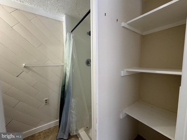 bathroom featuring a textured ceiling and walk in shower