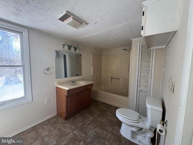 full bathroom featuring washtub / shower combination, vanity, toilet, and a textured ceiling