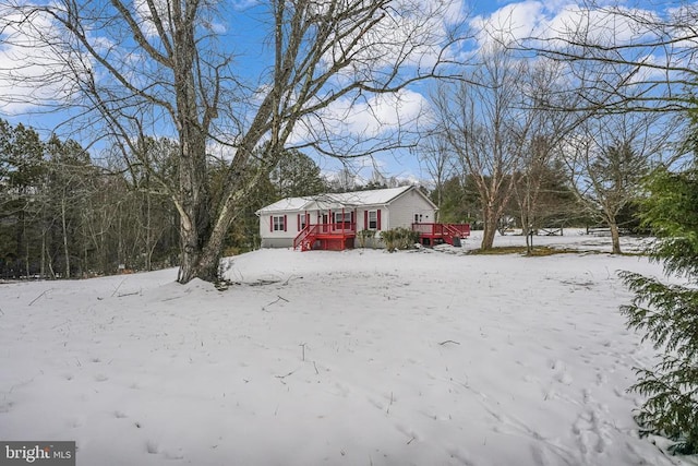 snowy yard featuring a wooden deck