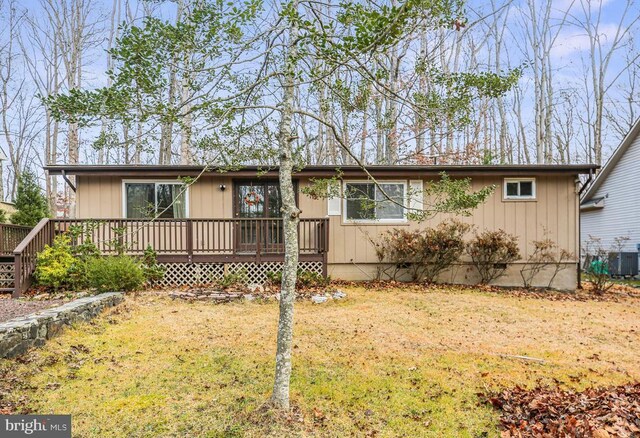 view of front of house with central AC unit, a deck, and a front lawn