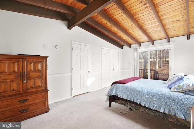 bedroom with lofted ceiling with beams, light colored carpet, and wood ceiling